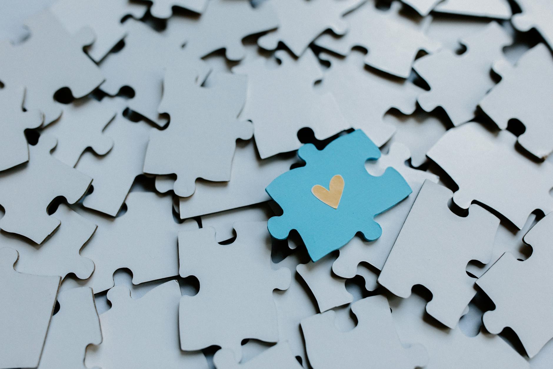 a puzzle piece with heart shaped icon on the pile of puzzle pieces